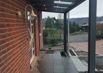 Schmale Terrasse mit Beleuchtung im Eingangsbereich als Hausvordach